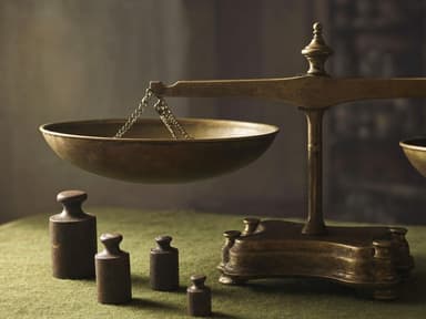 tarnished brass apothecary scales with worn iron weights on faded green felt cloth, single side lamp light, late afternoon